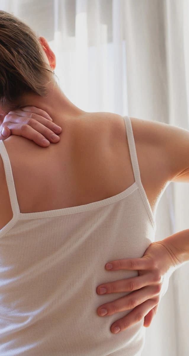 A person experiencing neck and back discomfort