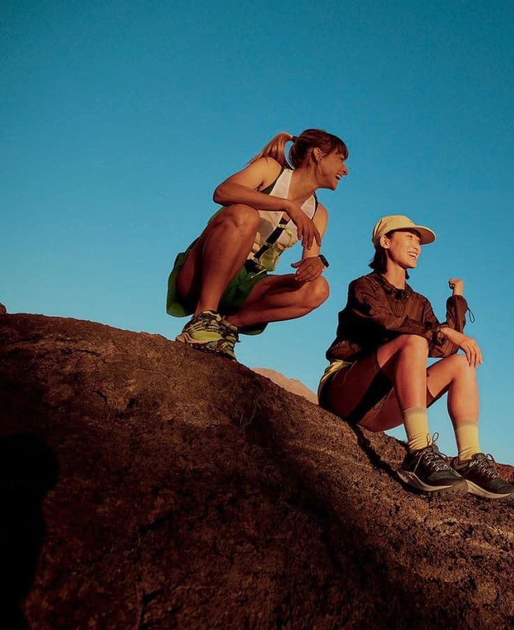 Two women sharing a supportive moment outdoors during a hike